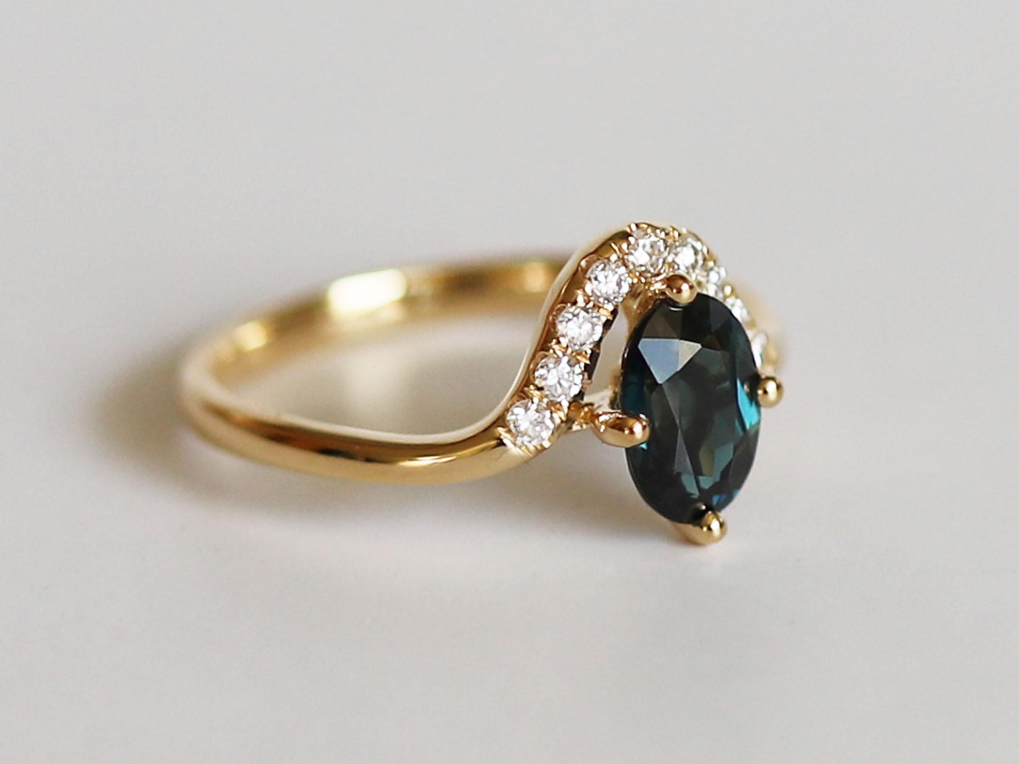 Diamond and teal sapphire ring in profile