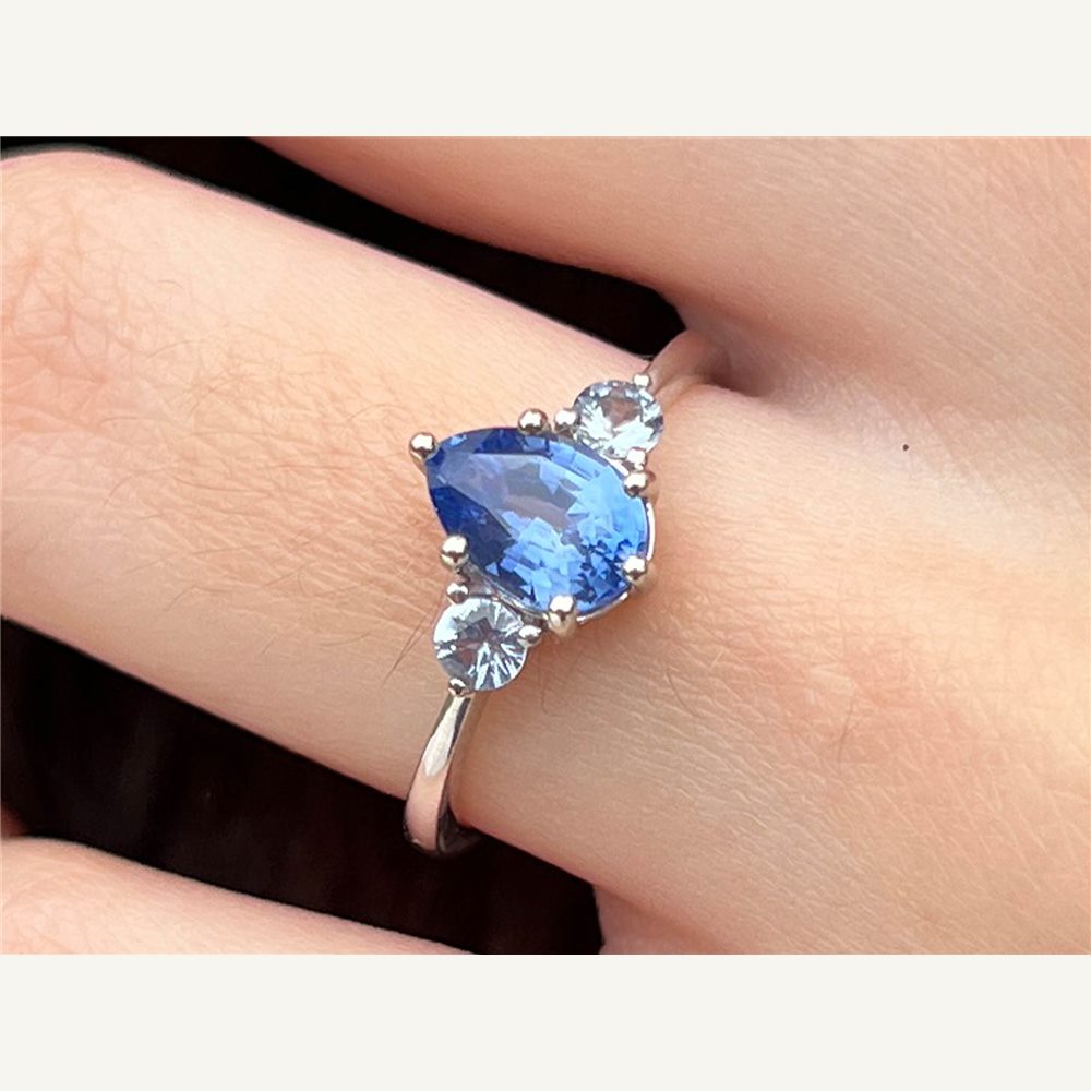 Clarisse ocean blue pear sapphire trilogy ring worn on hand